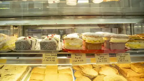 Lamingtons and cream buns in a cabinet